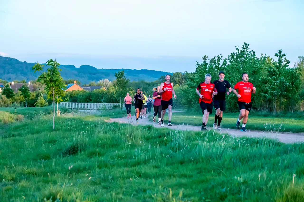 CRWC runners approaching along a path with local hills behind them
